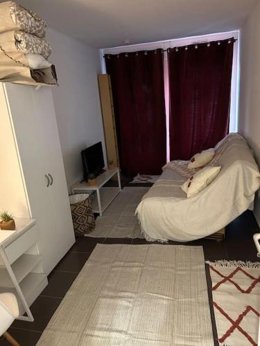 a small bedroom with a bed and a window at Chaleureux studio 3km de Luxembourg in Audun-le-Tiche