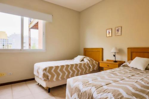 a bedroom with two beds and a window at Victoria Village in Carilo