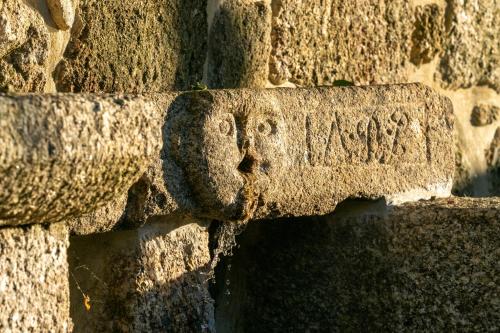 a stone wall with a carving on it at Quinta de Cypriano - Wine & Nature in Ponte da Barca