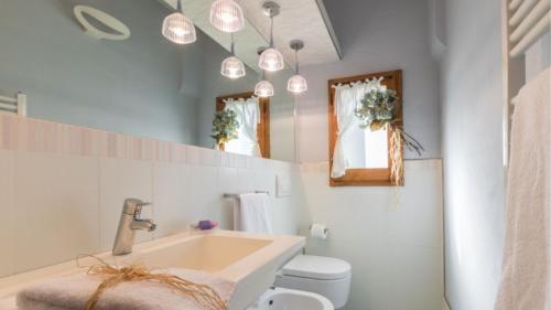 a bathroom with a sink and a toilet and lights at Villa cerreta in Massa e Cozzile