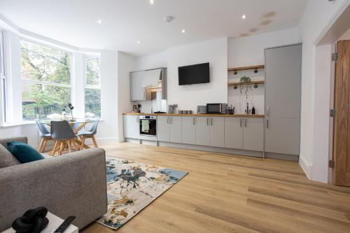 a kitchen and living room with a couch and a table at 1-Bed Apartment in Manchester by 53 Degrees Property, Ideal for Long Term, Couples or Business Groups! in Worsley