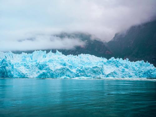 a large blue iceberg in a body of water at Loberias Del Sur in Puerto Chacabuco