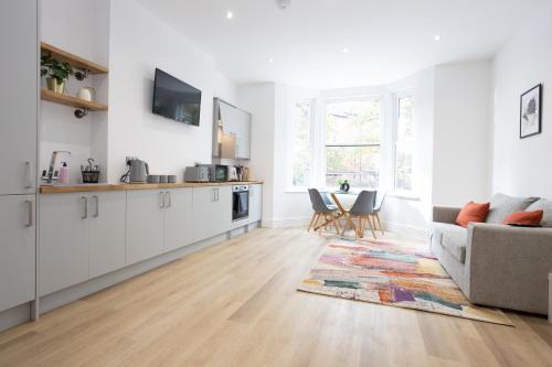 a kitchen and living room with a couch and a table at 1-Bed Apartment in Manchester by 53 Degrees Property, Ideal for Long Term, Couples or Business Groups! in Worsley