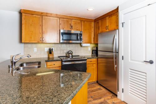 a kitchen with wooden cabinets and a stainless steel refrigerator at Marriott's Timber Lodge in South Lake Tahoe