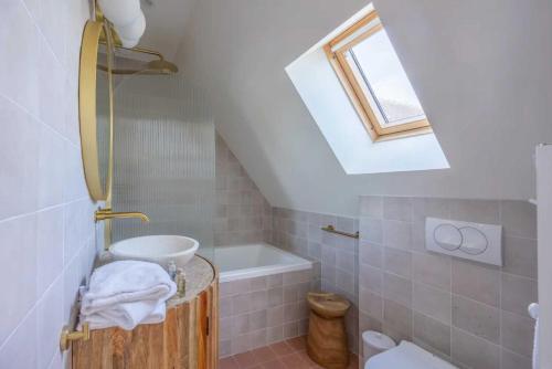 une salle de bain avec un lavabo et une baignoire dans l'établissement Charming house with garden in residence with pool, à Deauville