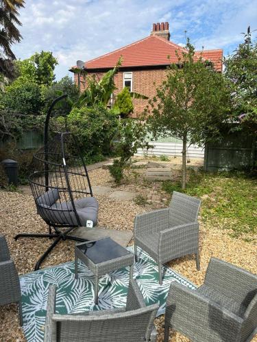 a group of chairs and a swing in a yard at Park View is a beautiful whole entire house close to town centre, sleeps 8 in 4 rooms, 2 doubles and 4 single beds with 2 shower rooms, available for holidays, insurance stays, trades people, contractors, pets welcome in Wisbech