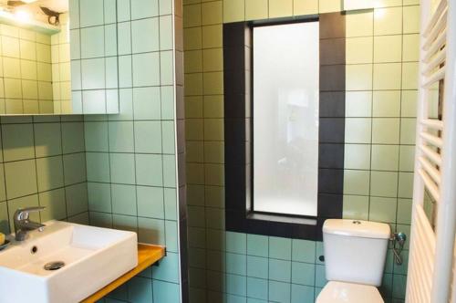une salle de bain avec un lavabo et des toilettes et une fenêtre dans l'établissement Good News - Bonne Nouvelle, à Paris