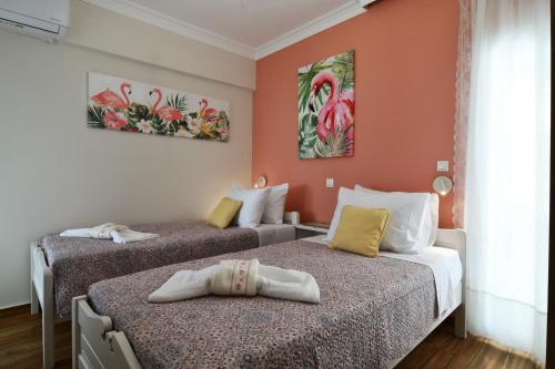 two beds in a room with orange walls at Favola Golden Beach Villa in Daratso