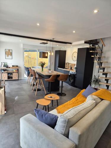 un salon et une cuisine avec un canapé et une table dans l'établissement Casa Délia, maison lumineuse et moderne, à Belz