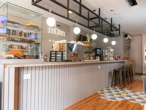 a restaurant with a counter with chairs and lights at Hotel Quinto Nivel in San José del Guaviare