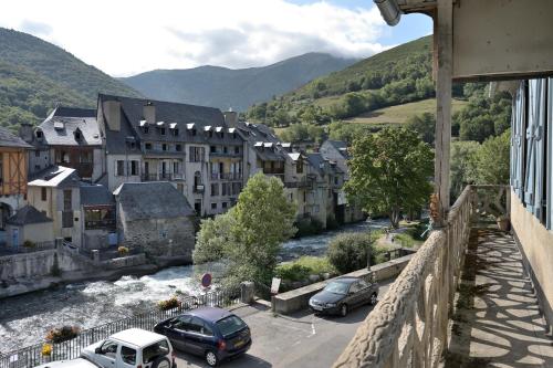 a view of a town with cars parked next to a river at Maison de caractère vue sur Neste in Arreau