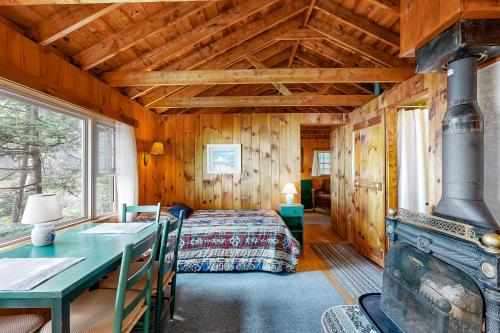 a bedroom with a bed and a fireplace in a cabin at Evergreen in Northport