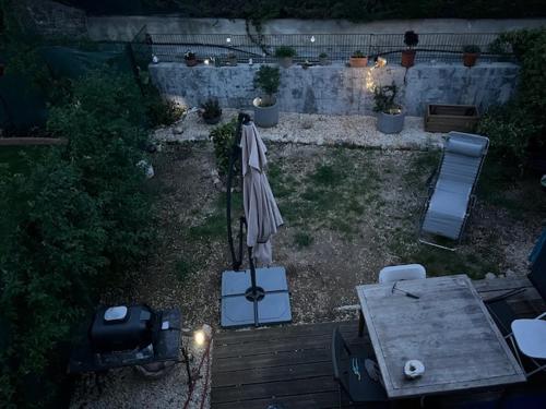 - une terrasse avec un parasol, une table et un grill dans l'établissement Location maisonnette avec jardinet, à Vallauris