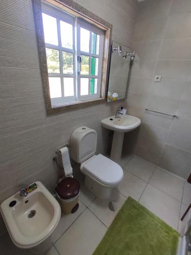 a bathroom with a sink and a toilet and a bidet at Varanda do Sardoal in Penafiel