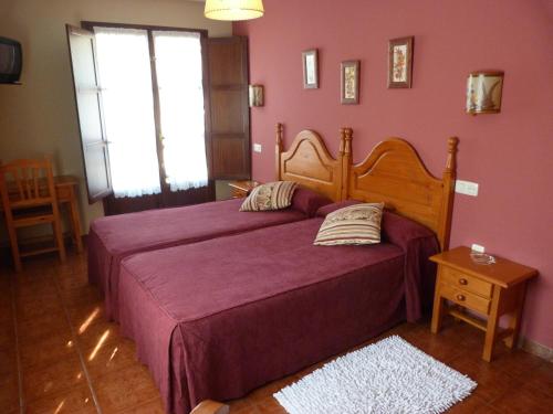 a bedroom with a large bed with purple sheets at Hotel Mestas in Arenas de Cabrales