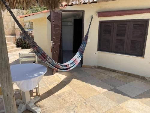 a hammock sitting outside of a house at Pousada Vila Canoa in Canoa Quebrada