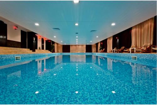 ein großer Swimmingpool in einem Hotelzimmer in der Unterkunft Yanevi Apartments at Grand Monastery Pamporovo in Pamporowo