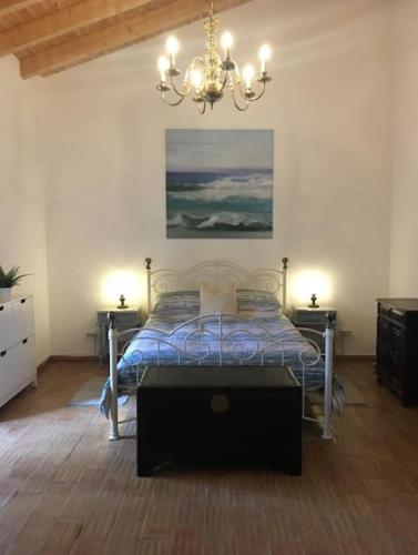 Un dormitorio con una cama y una lámpara de araña. en San Salvatore, en Querença
