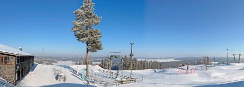 a snow covered ski slope with a ski lift at Paritalomökki Lomariihi 4 in Muurame