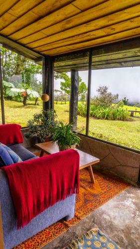 a living room with a couch and a table at Poas Volcano Lodge in Vara Blanca