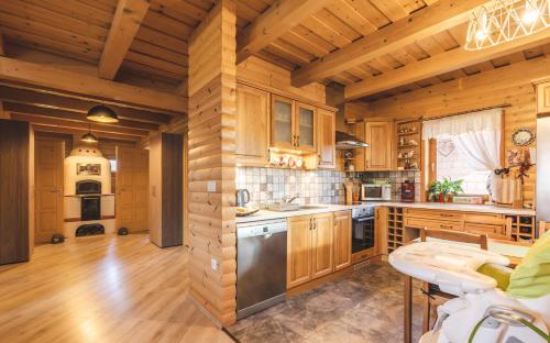 a kitchen with wooden walls and wooden flooring at Restnest Vendégház: Infraszauna+Dézsafürdő in Dunasziget