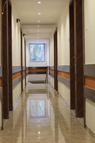 a hallway with wooden doors and a window at Hotel Metro Inn in Mumbai
