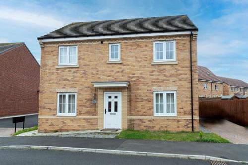 a brick house with a white door on a street at Supreme House in Middlesbrough