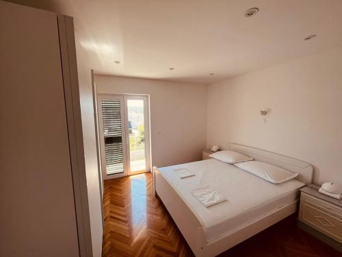 a small bedroom with a bed and a window at Apartments Anica in Primošten