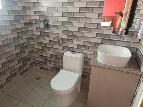 une salle de bain avec des toilettes blanches et un lavabo dans l'établissement Om hotel, à Rohtak