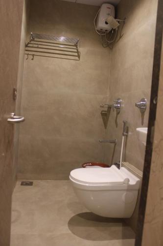 a bathroom with a toilet and a sink at Hotel Metro Inn in Mumbai