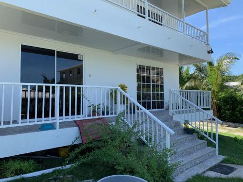 a white house with stairs leading to a balcony at Apartamentos The Captain and His Queen in Playa Aguadulce