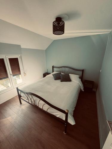 Ce lit se trouve dans une chambre dotée d'un mur bleu. dans l'établissement Gîte saint Bernard, à Sedan