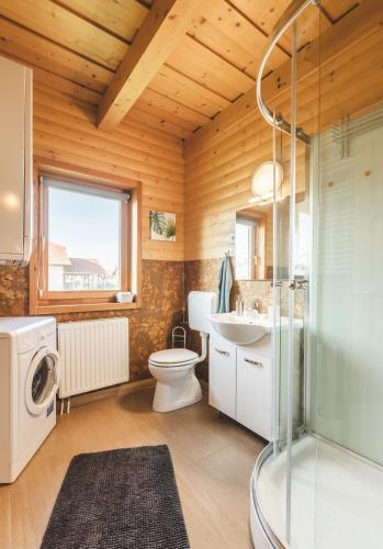 a bathroom with a shower toilet and a sink at Restnest Vendégház: Infraszauna+Dézsafürdő in Dunasziget