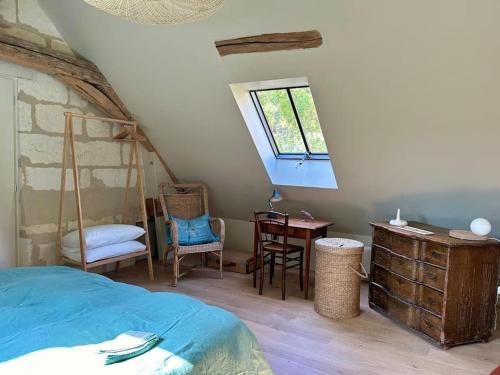 une chambre avec un lit, un bureau et une fenêtre dans l'établissement Appartement à l'abri du donjon, à Loches