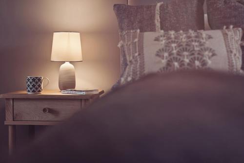 a lamp on a night stand next to a bed at Ingleborough in Carnforth