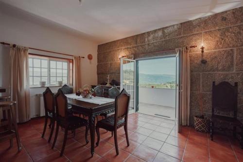 a dining room with a table and chairs and a window at A Casa do Pereira by LovelyStay in Urgueira