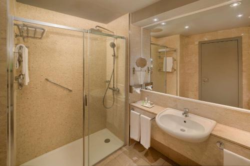 a bathroom with a shower and a sink and a shower at NH Torino Lingotto Congress in Turin