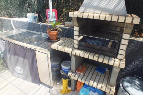 a barbecue grill with a sink in a backyard at AL "Villa Por Do Sol" Sunset Olhão in Olhão