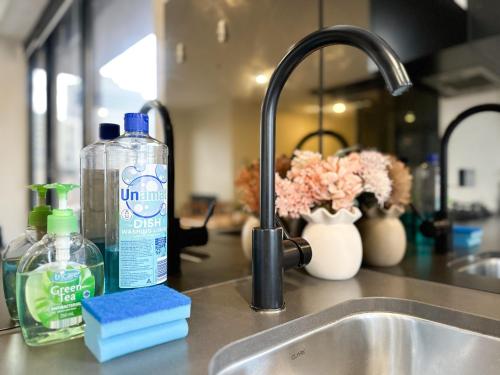 a kitchen sink with a bottle of detergent next to it at City Central 2BR Retreat on Chinatown Bourke Street in Melbourne