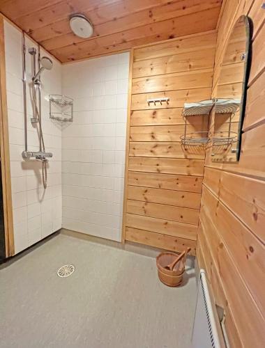 a bathroom with wooden walls and a shower stall at Lomariihi 8 in Muurame