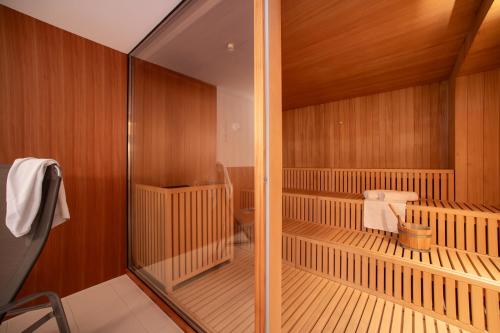 a room with a sauna with wooden walls and a glass door at Bed & Breakfast Hotel Nives in Solda