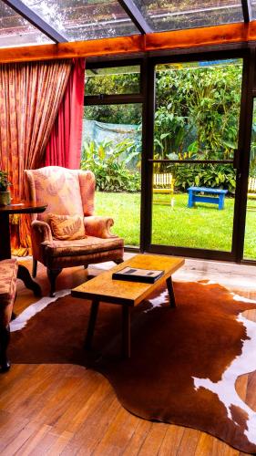 a living room with a chair and a coffee table at Poas Volcano Lodge in Vara Blanca