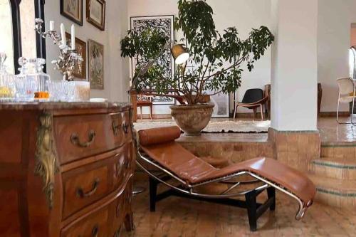 a living room with a chair and a dresser at Villa d architecte Marrakech in Oulad Jellal