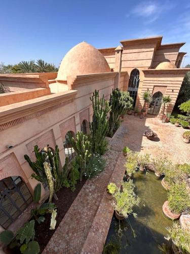 a house with a pond in front of a building at Villa d architecte Marrakech in Oulad Jellal