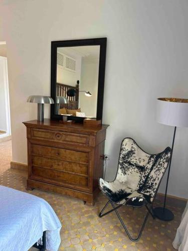 a bedroom with a dresser and a chair and a mirror at Villa d architecte Marrakech in Oulad Jellal