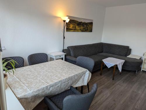 a living room with a couch and a table and chairs at Ferienwohnung Oker - City Center - Keybox and Balkony in Braunschweig
