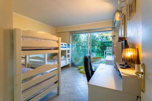 Cette chambre dispose de lits superposés et d'un bureau avec un ordinateur. dans l'établissement BELLES TERRES 2 AP4392 By Riviera Holiday Homes, à Nice
