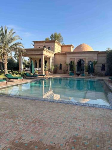 a large swimming pool in front of a house at Villa d architecte Marrakech in Oulad Jellal