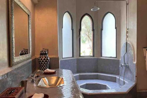 a bathroom with a tub and a sink at Villa d architecte Marrakech in Oulad Jellal