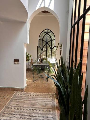 a hallway with a table and a potted plant at Villa d architecte Marrakech in Oulad Jellal